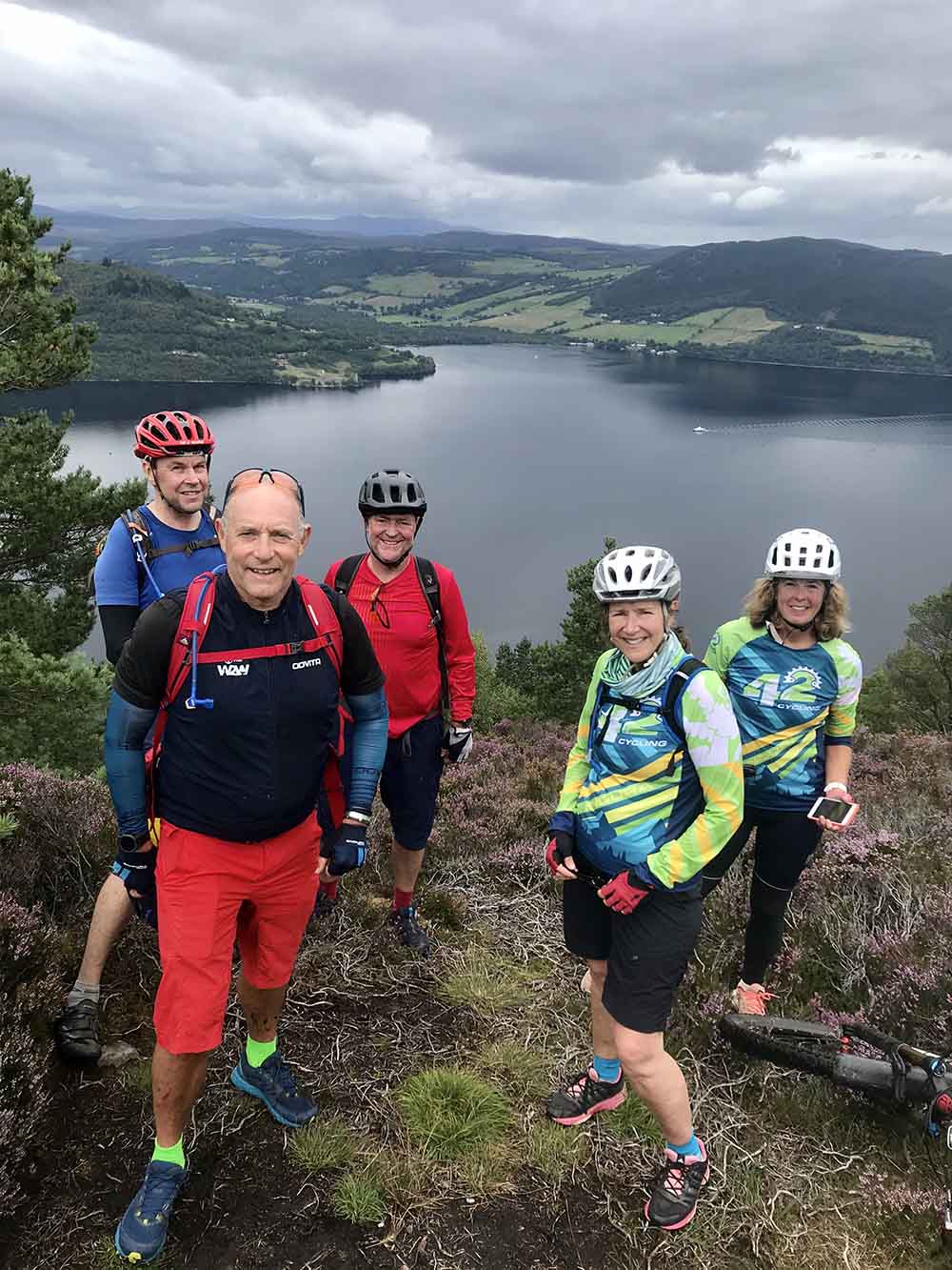 Photo of happy cyclists overlooking a lake