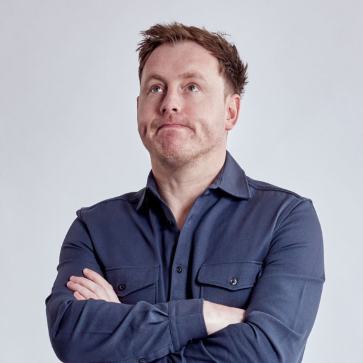 Andrew Ryan looking up with his arms crossed