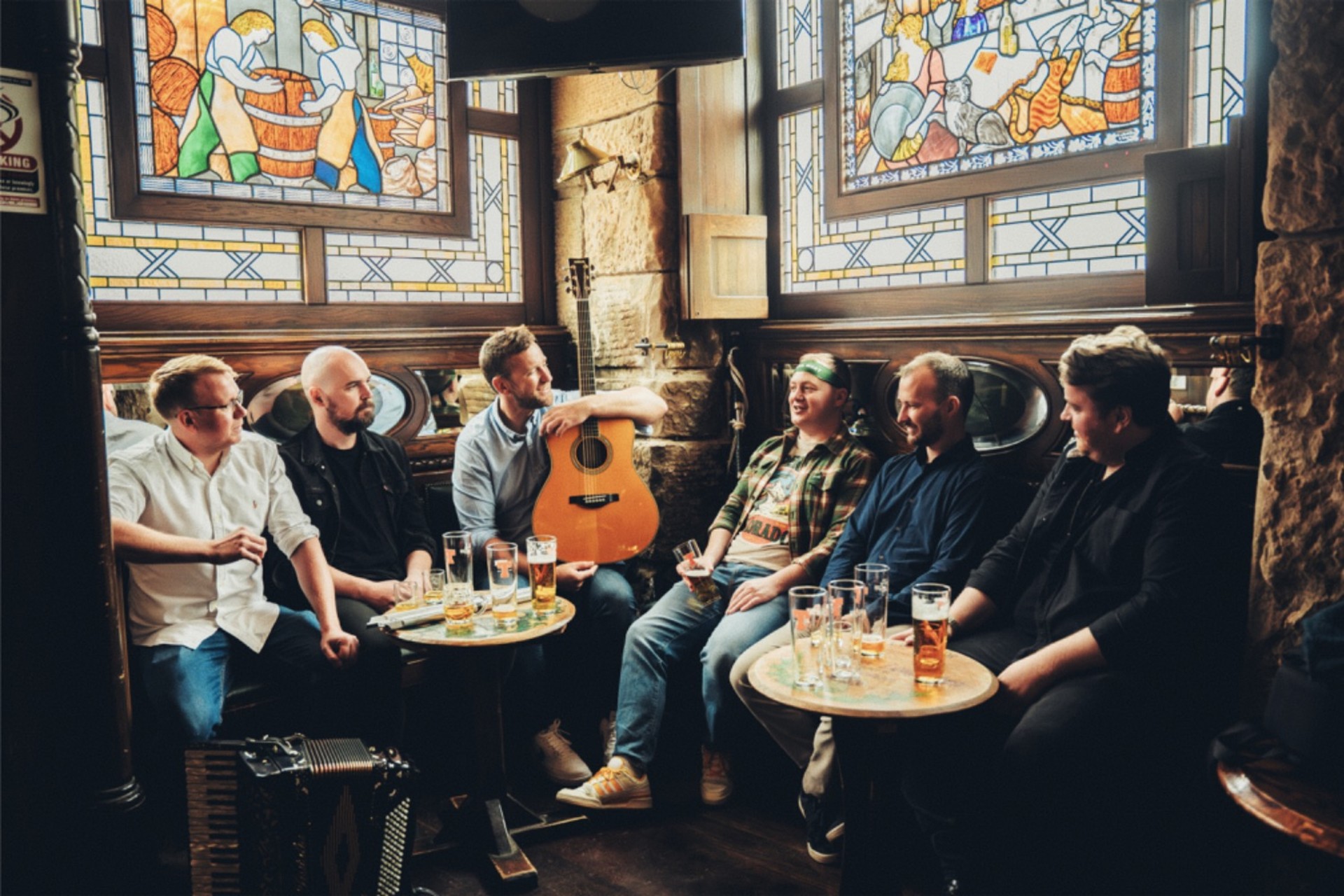 The six members of Trail West siting around two tables in a pub